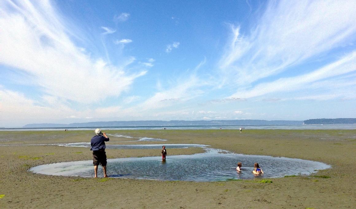 Kids wading in shallows at Jetty Island near Everett one of the best kids' beaches on Puget Sound near Seattle